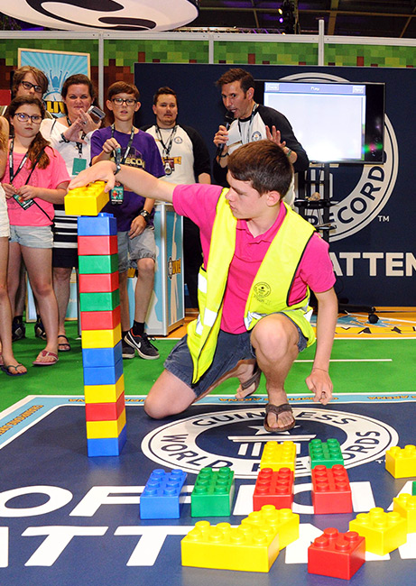 man with high vis building lego blocks