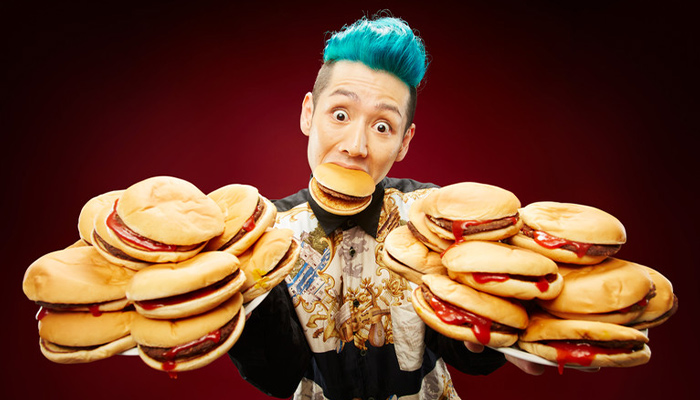 man holding multiple burgers