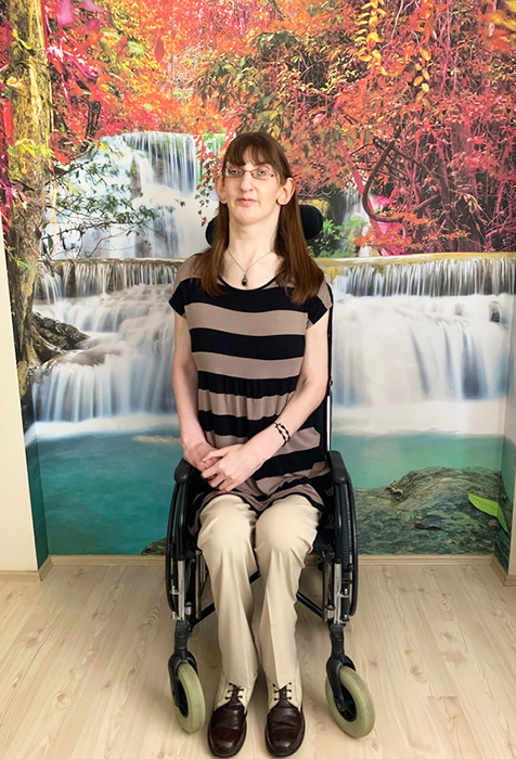 Rumeysa sitting down in front of painting