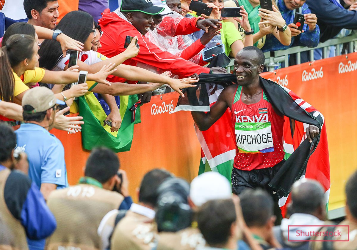 Eliud smiling while high-fiving fans