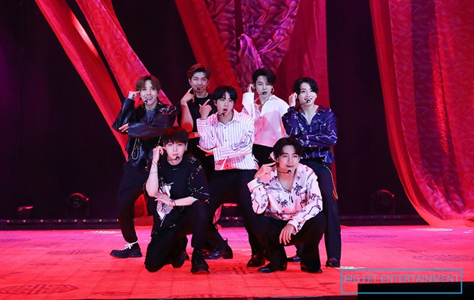 BTS performing live in a red background