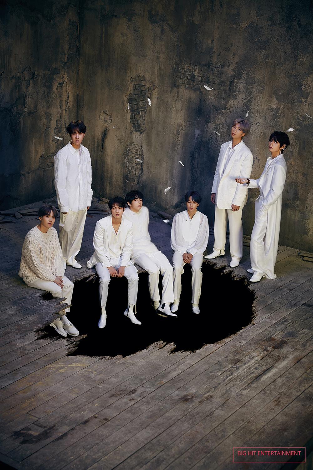 group picture with BTS wearing all white in a room with a hole in the floor